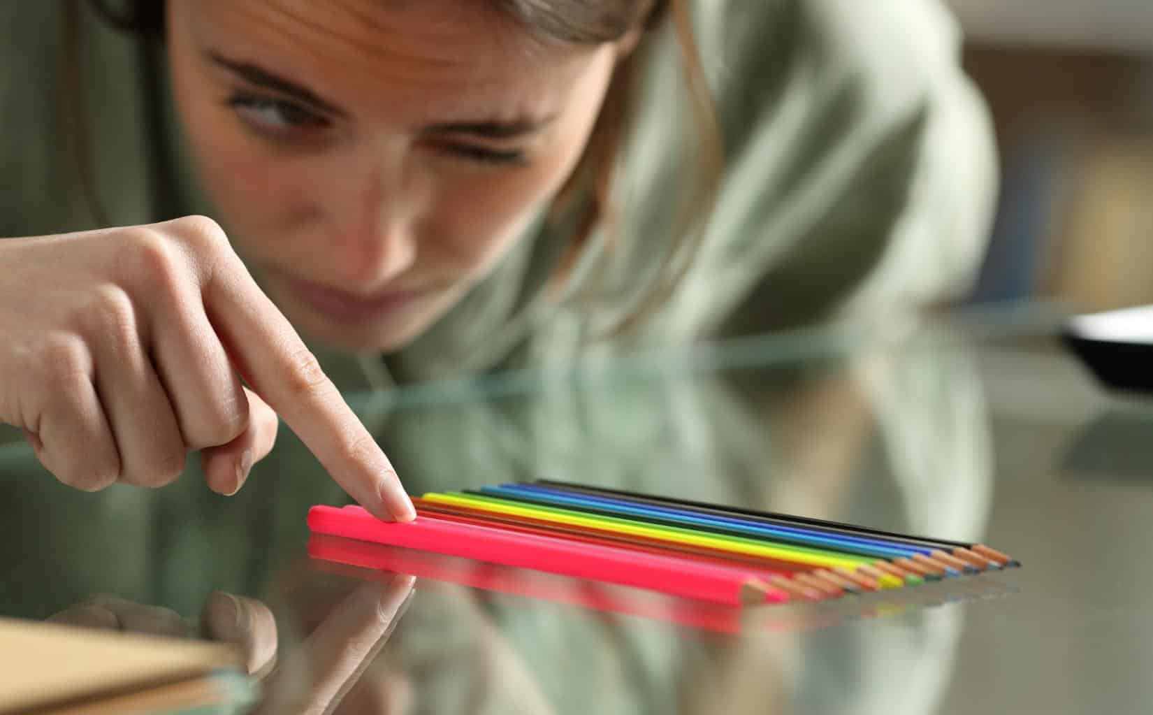 Woman organizing colored pencils by color.