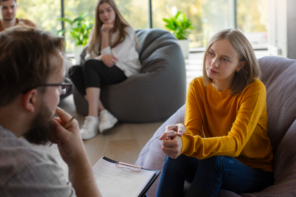 Woman speaking with a therapist during a group session for women’s mental health treatment in Massachusetts.
